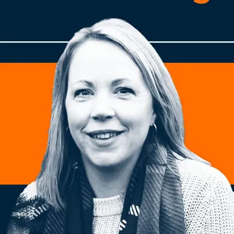 Smiling woman with straight hair wearing a knit sweater and scarf against an orange and navy backdrop.